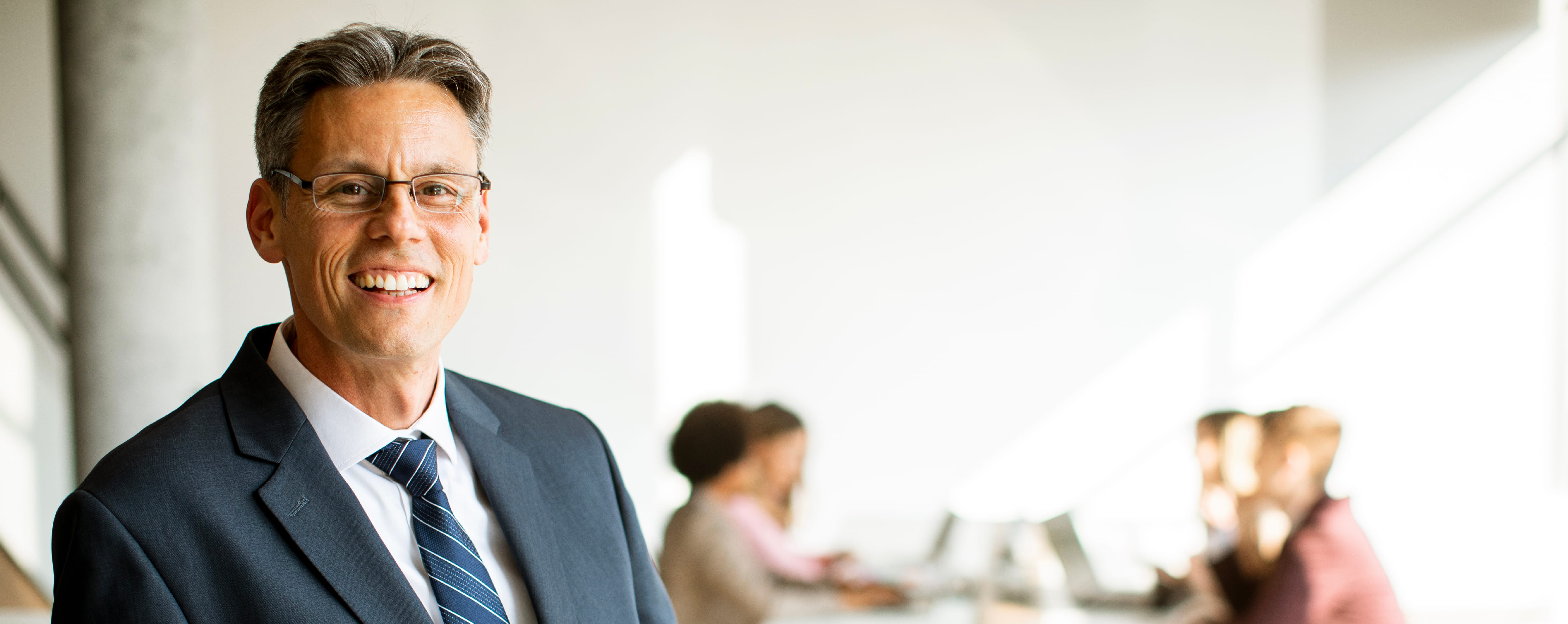 Business executive smiling in an office setting.
